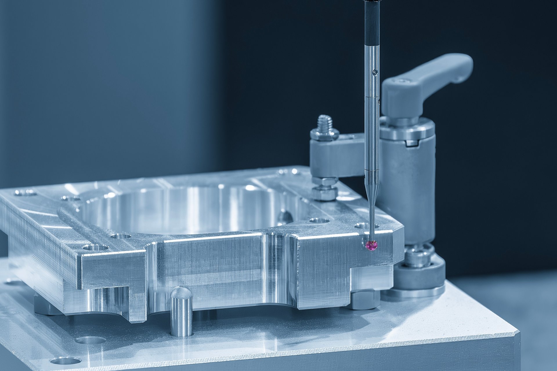 Image of machined part being inspected by CMM probe stylus.