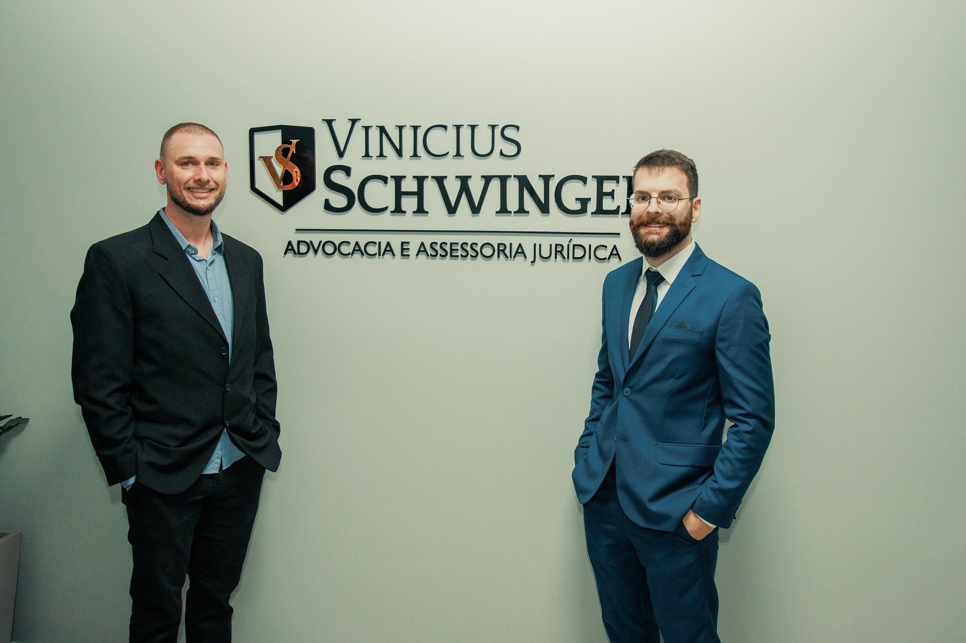 Dois homens em pé um ao lado do outro em um escritório jurídico.