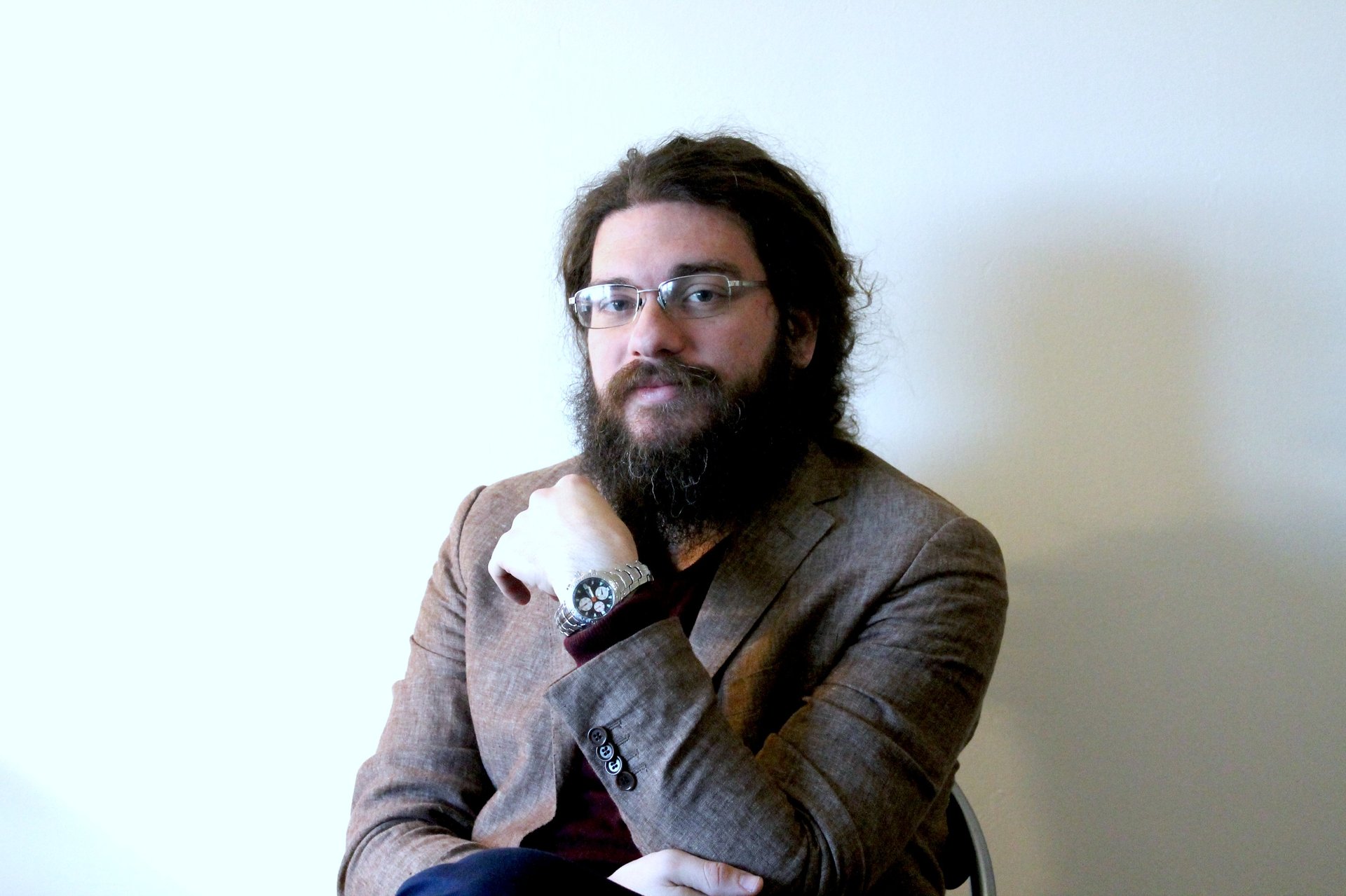 a man with a beard and glasses on a chair