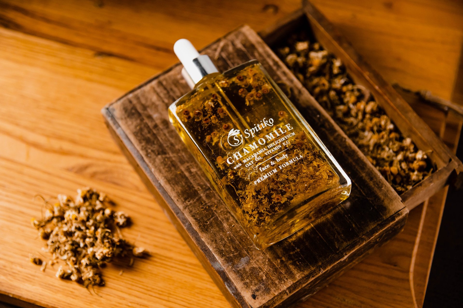 a bottle of oil with a wooden box and some nuts