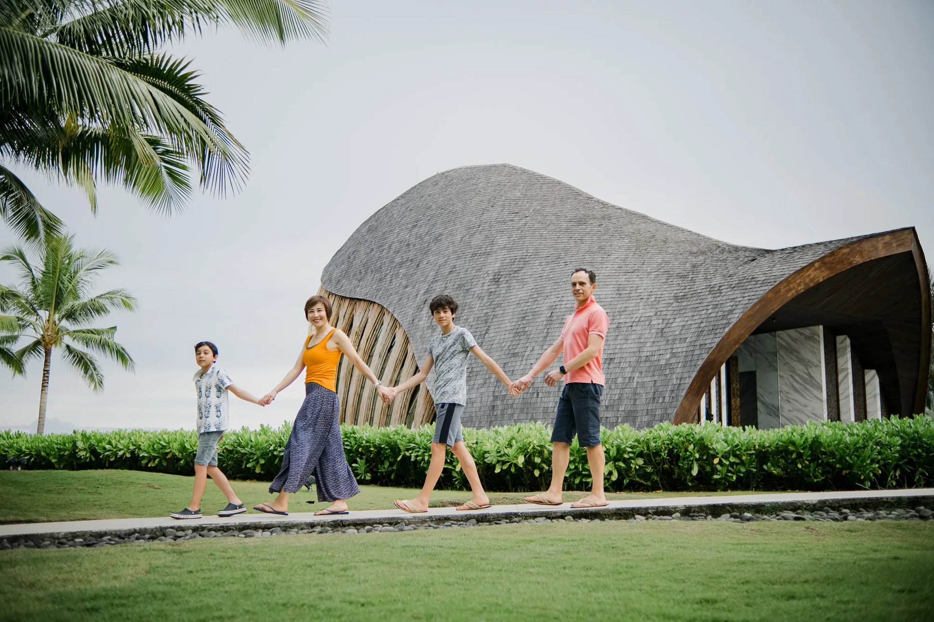 Family photography session walking beside the oceanfront chapel at The Apurva Kempinski Bali