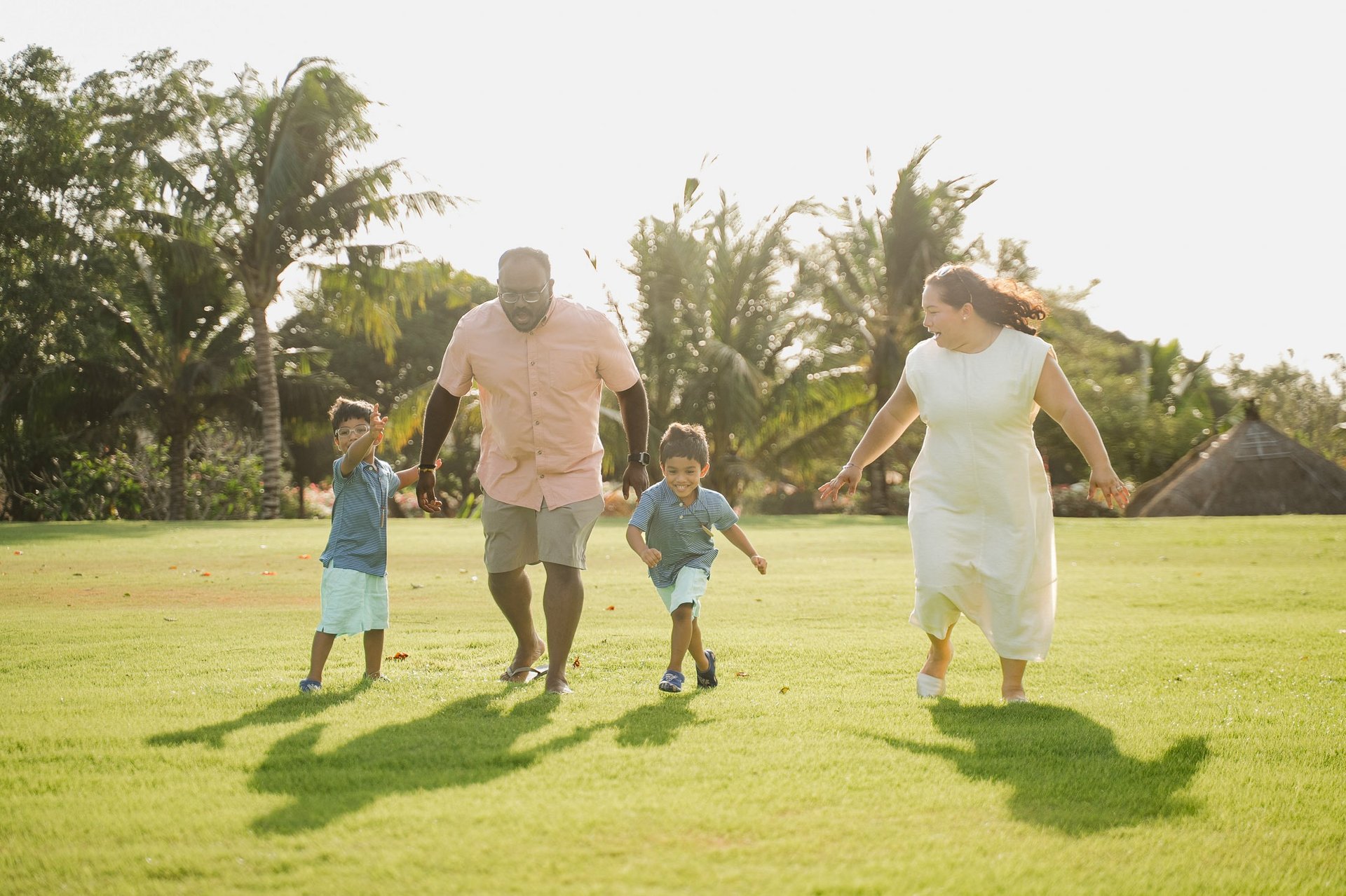 parents walking with their children on the lawn at rimba by ayana bali during family photography