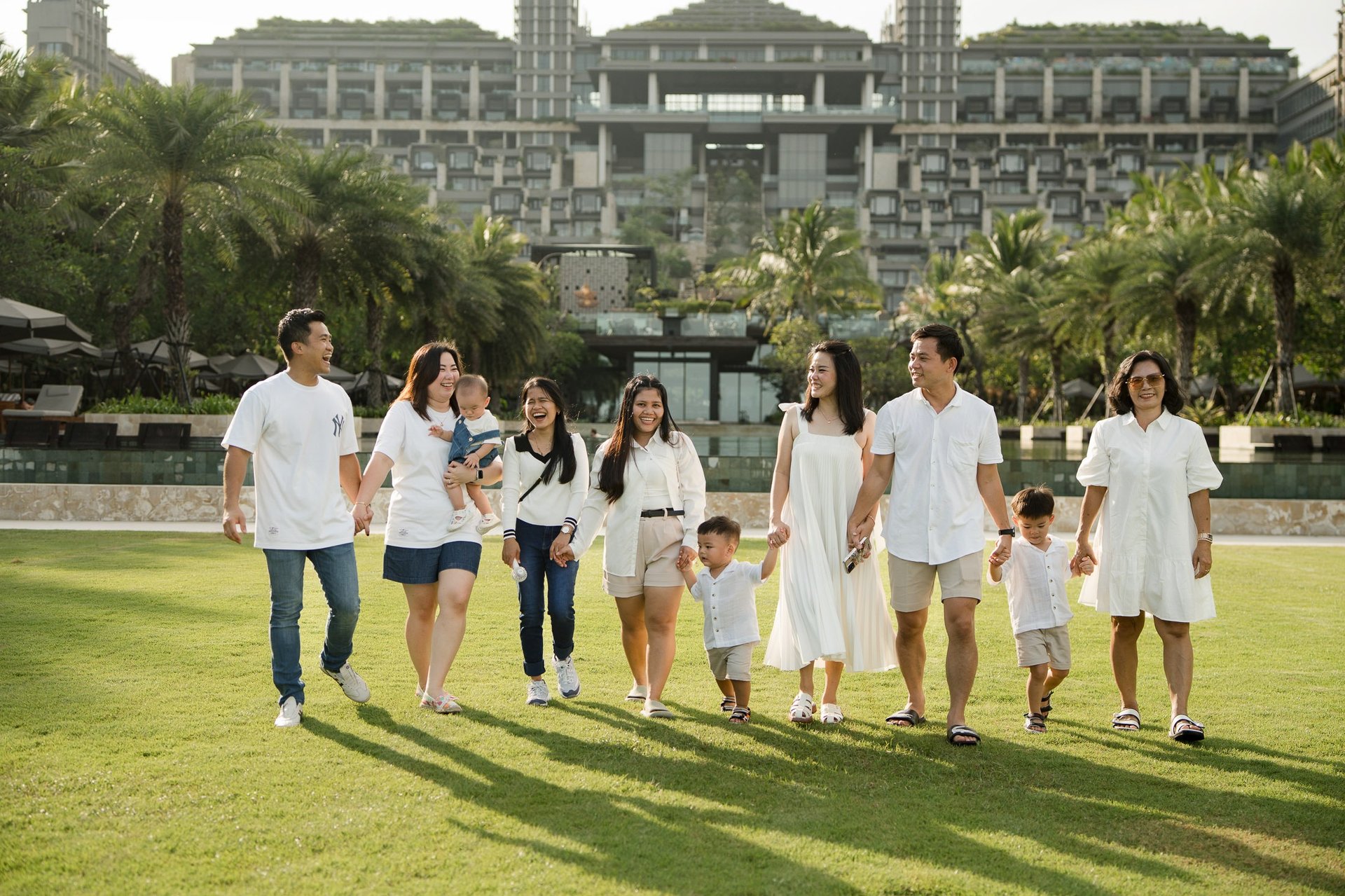 Large family walking together on the lawn at The Apurva Kempinski Nusa Dua Bali