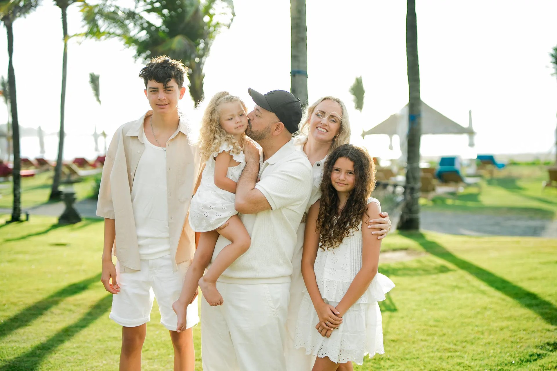 Parents and children sharing playful moments on the tropical lawn at Ayodya Resort Bali