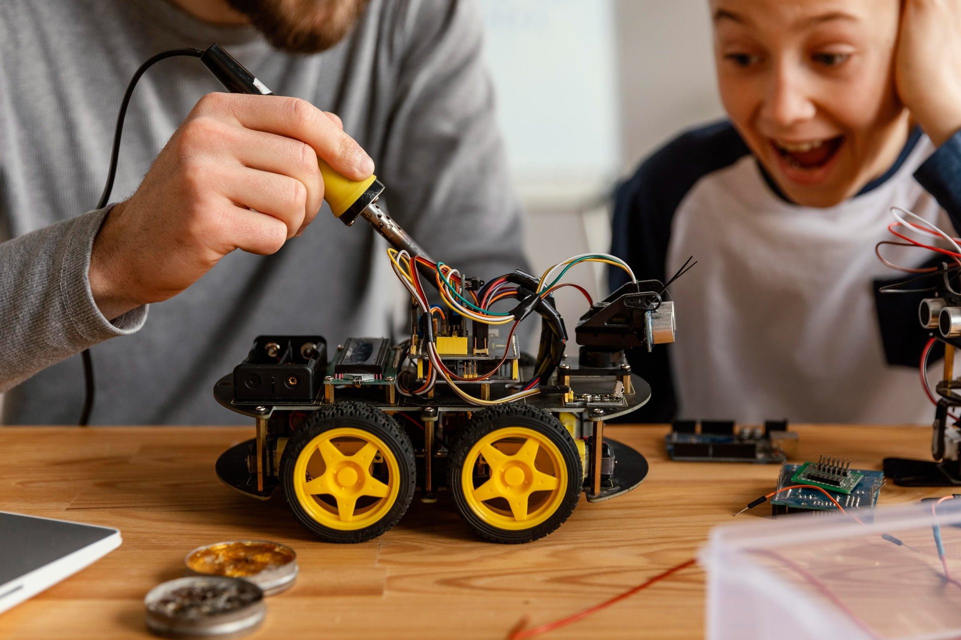a man and a boy are building a robotic car