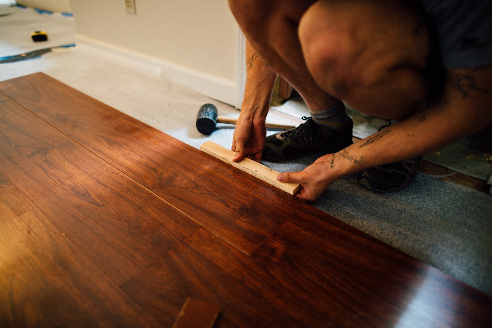 a man is using a tape measure ruler to measure a hardwood floor