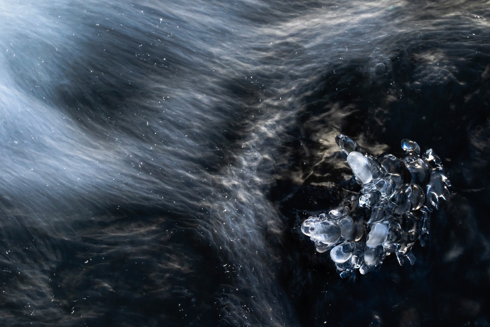 a piece of ice with water and ice crystals