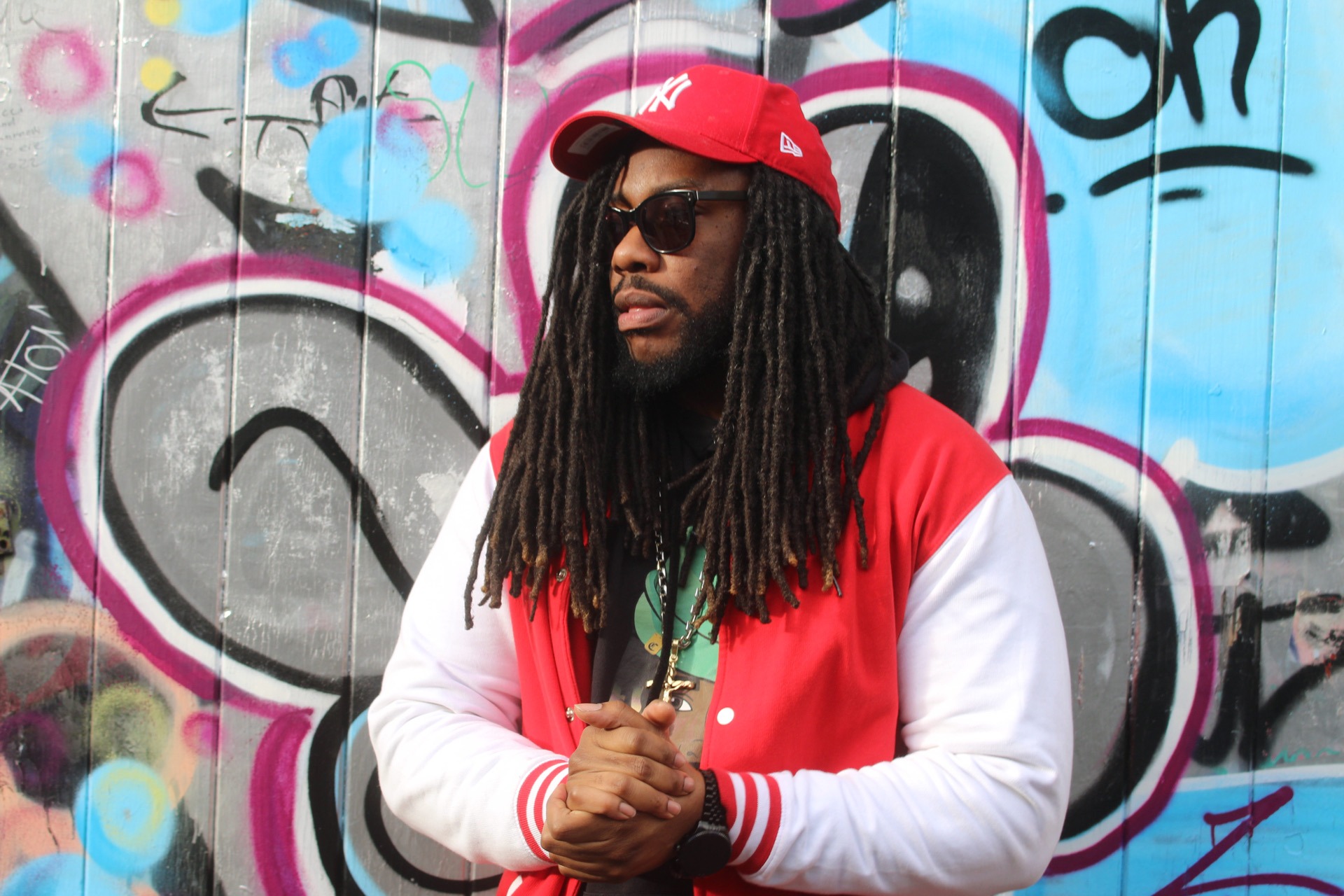 a man with dreadlocks and a red jacket