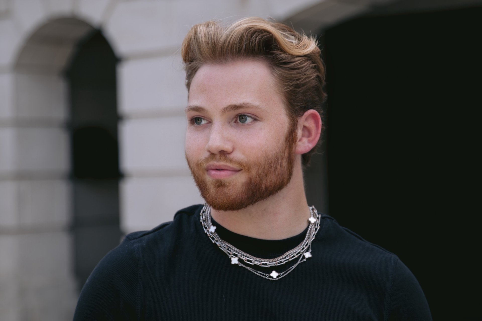 a man with a beard and a chain link necklace