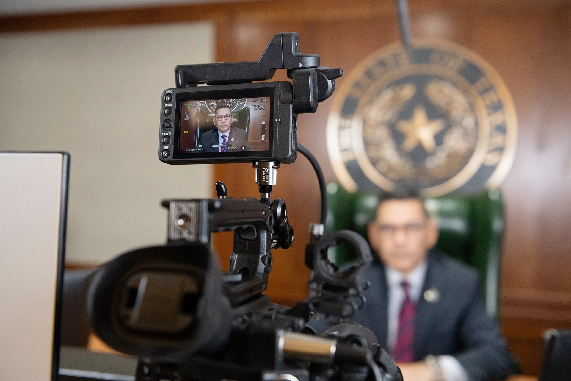 Texas Workforce Commissioner Julian Alvarez being recorded with a professional video camera.