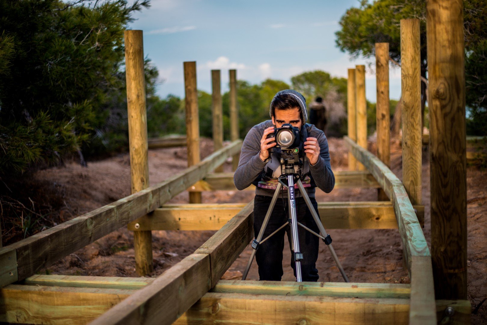 un hombre tomando una fotografía en un antiguo puente de madera