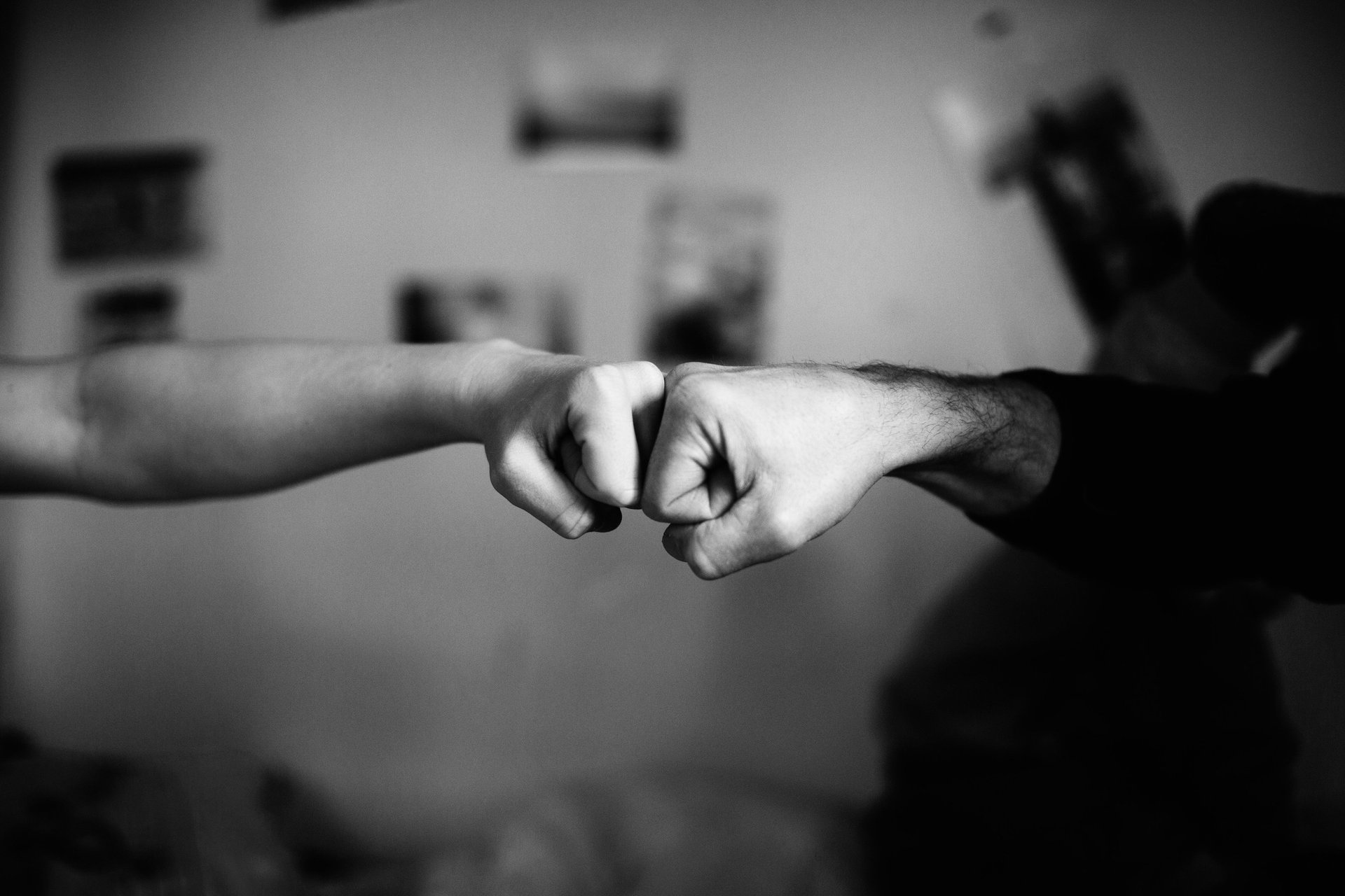 black and white photo of a fist bump