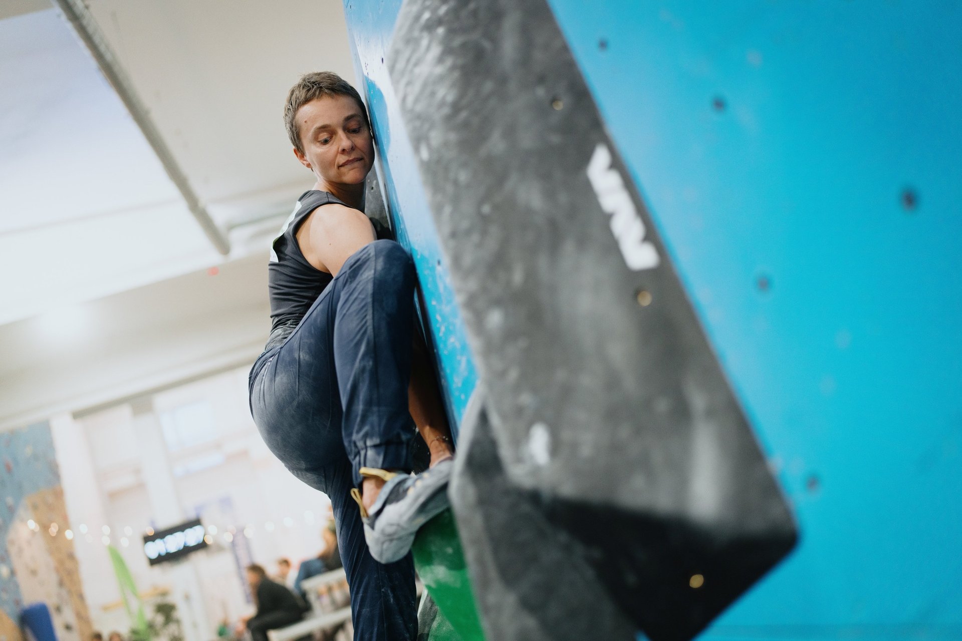 a woman bouldering on a climbing wall