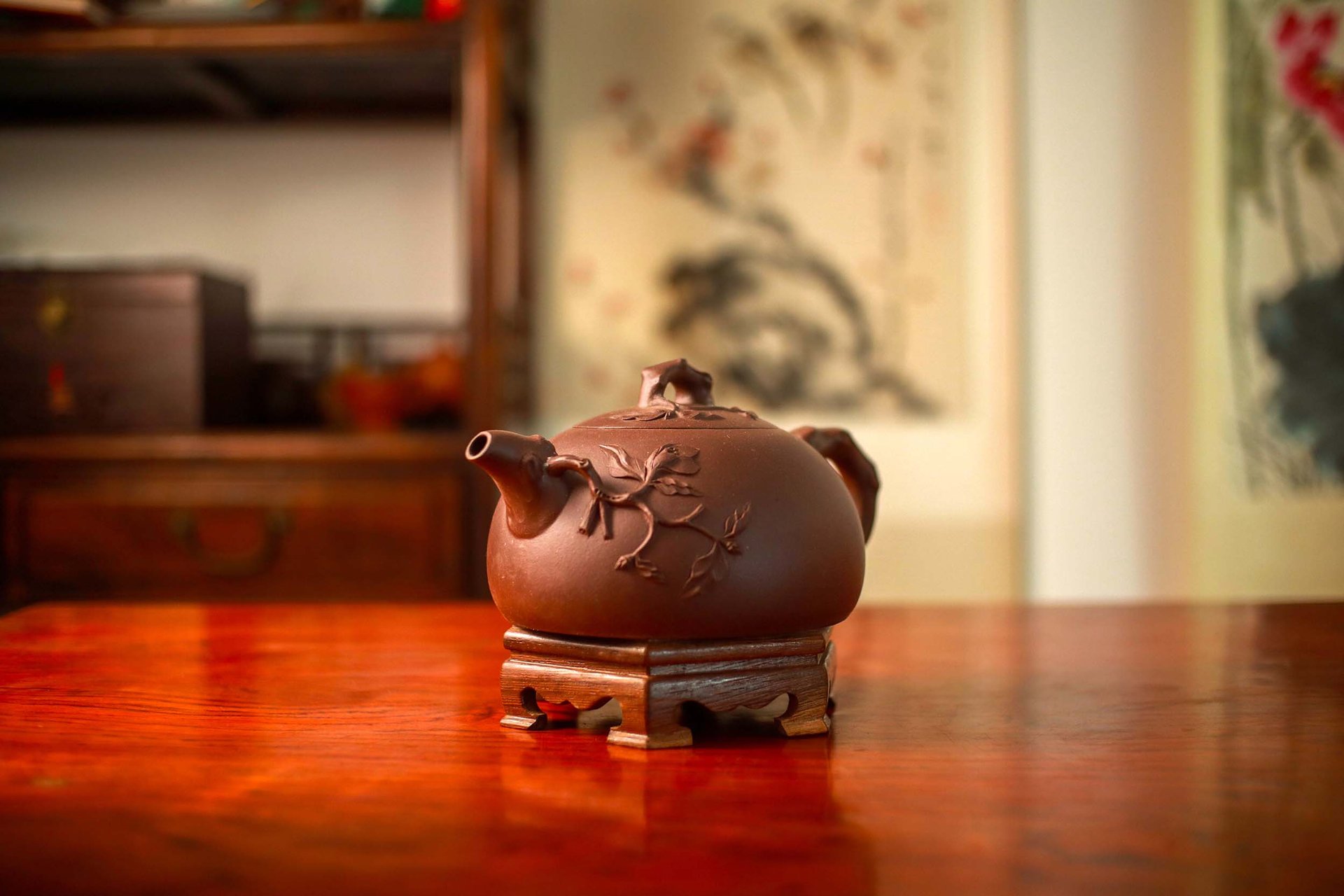 Teapot with an accentuated design placed on a wooden stand