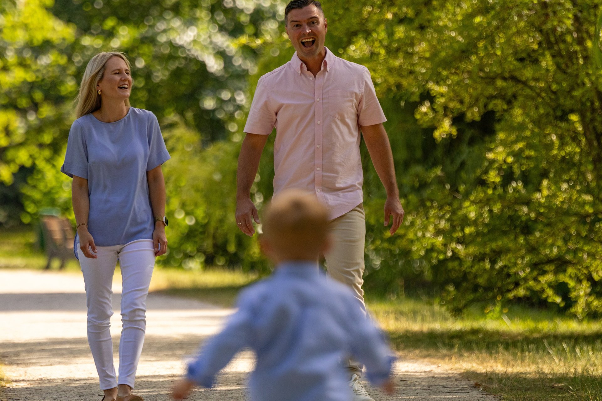 Familienshooting Coburg: Fröhlicher Sohn rennt lachend auf seine Eltern zu, pure Lebensfreude.