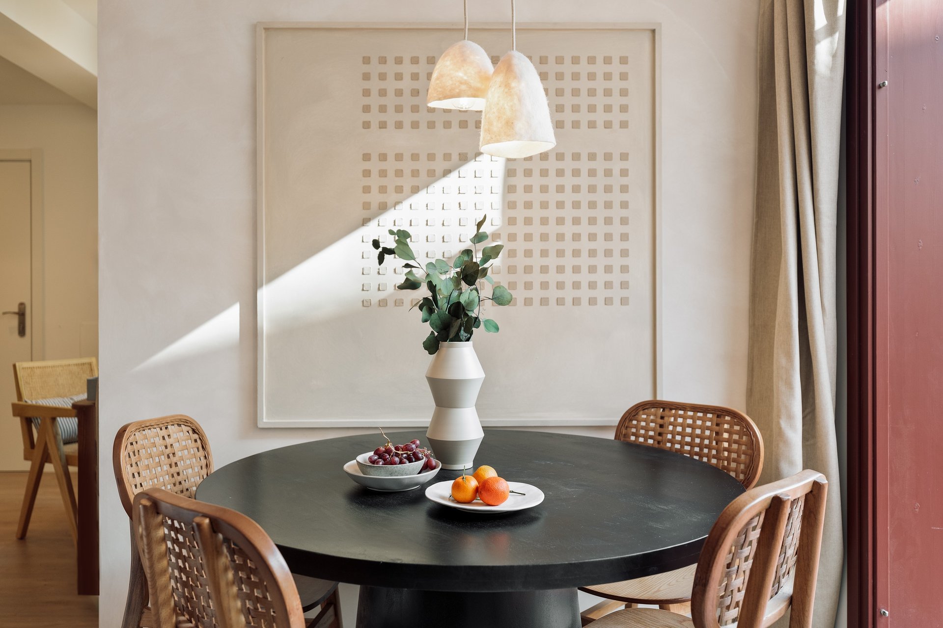 Subtle dining area with custom art piece and natural wood accents in Barcelona