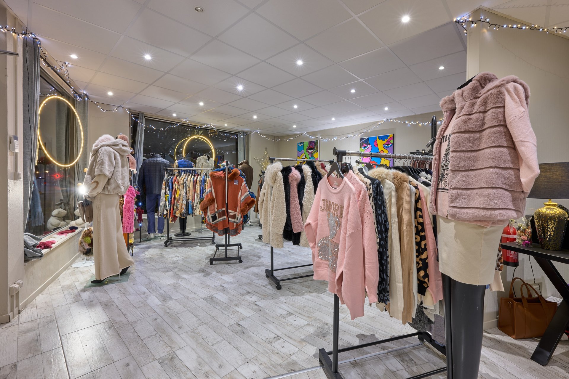 Intérieur d'une boutique de vêtements présentant des vêtements, des manteaux, des pulls de créateur