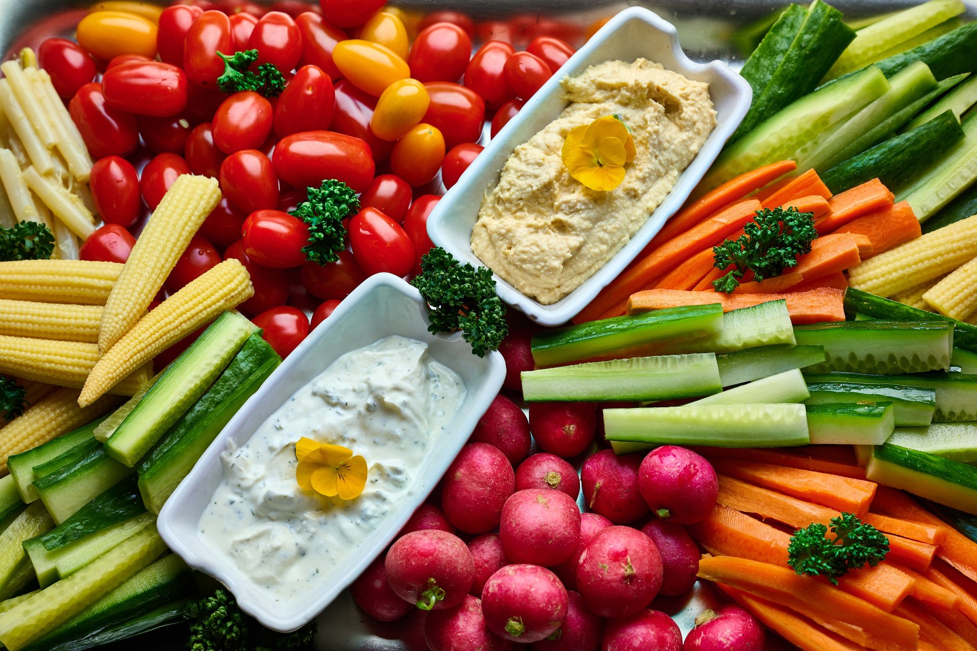 Assiette de crudités fraîches avec houmous, carottes, concombres, radis et tomates