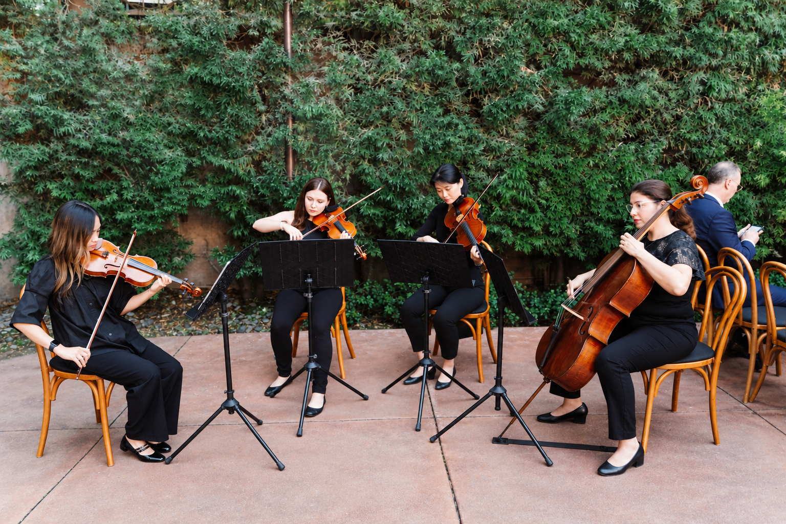 A wedding string quartet performs outdoors at a wedding at Franciscan Gardens in San Juan Capistra