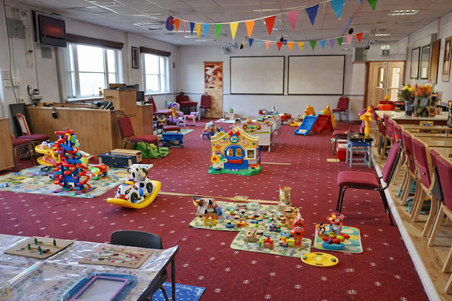 Play area inside New Life Church baby & toddler group in Saffron Walden with toys, soft play, slides and seating for parents.