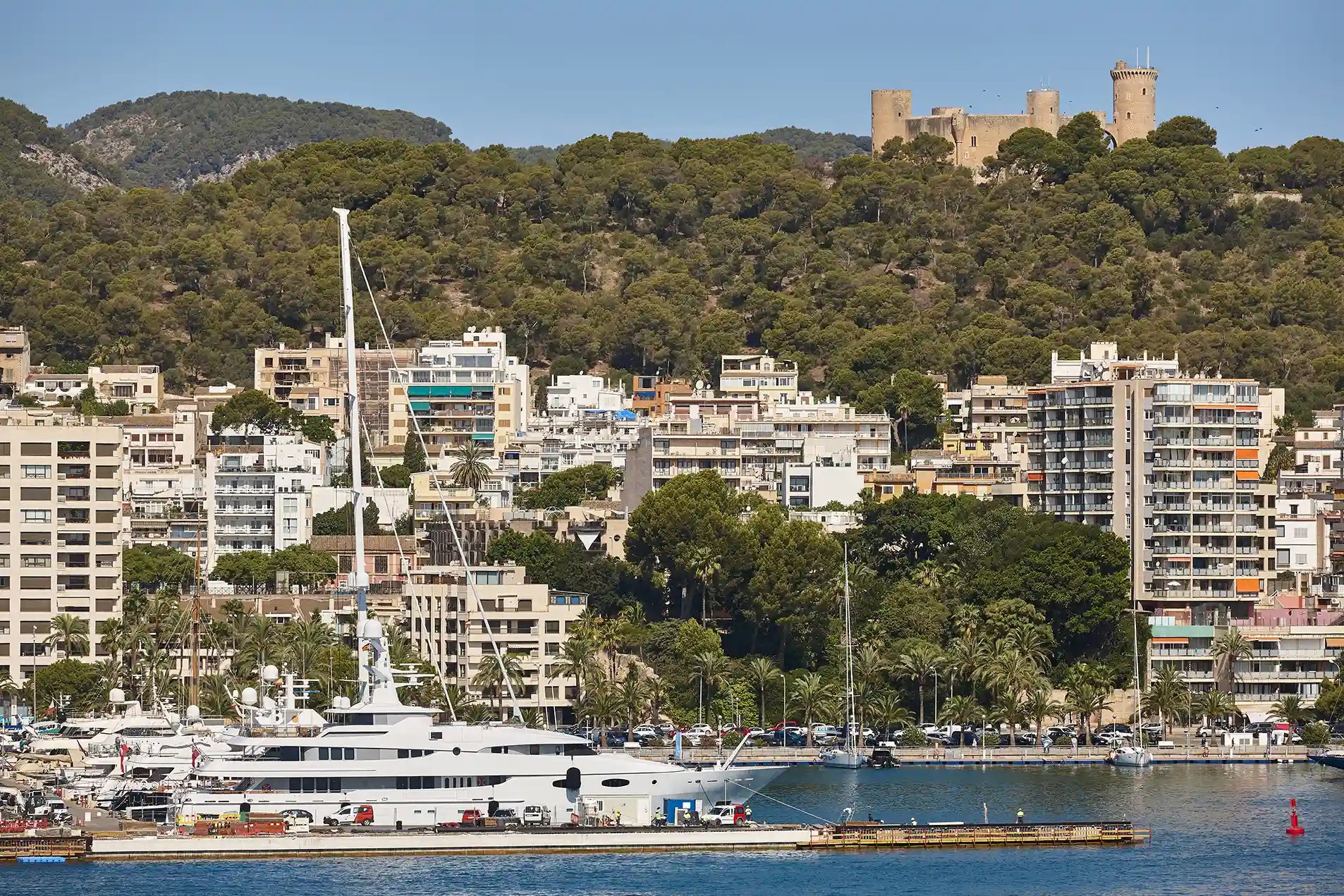Vista de Palma con puerto, edificios residenciales y el castillo de Bellver al fondo