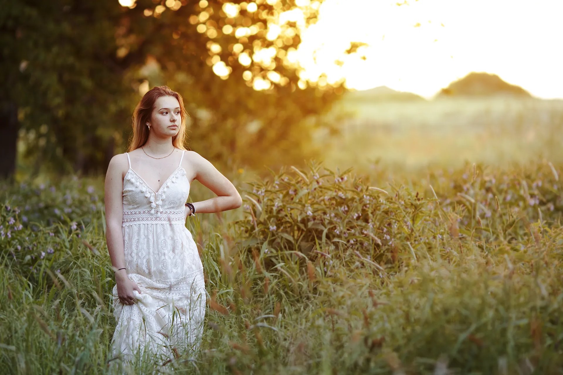 une jeune femme dans la campagne au coucher du soleil