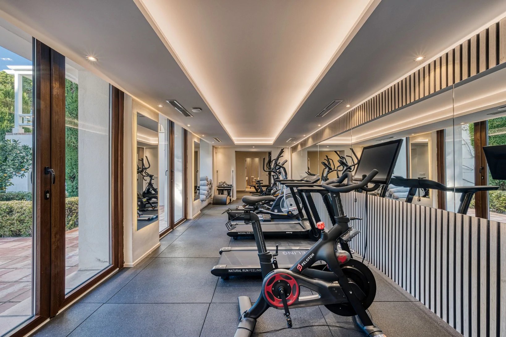Private gym with cardio equipment and mirrored walls