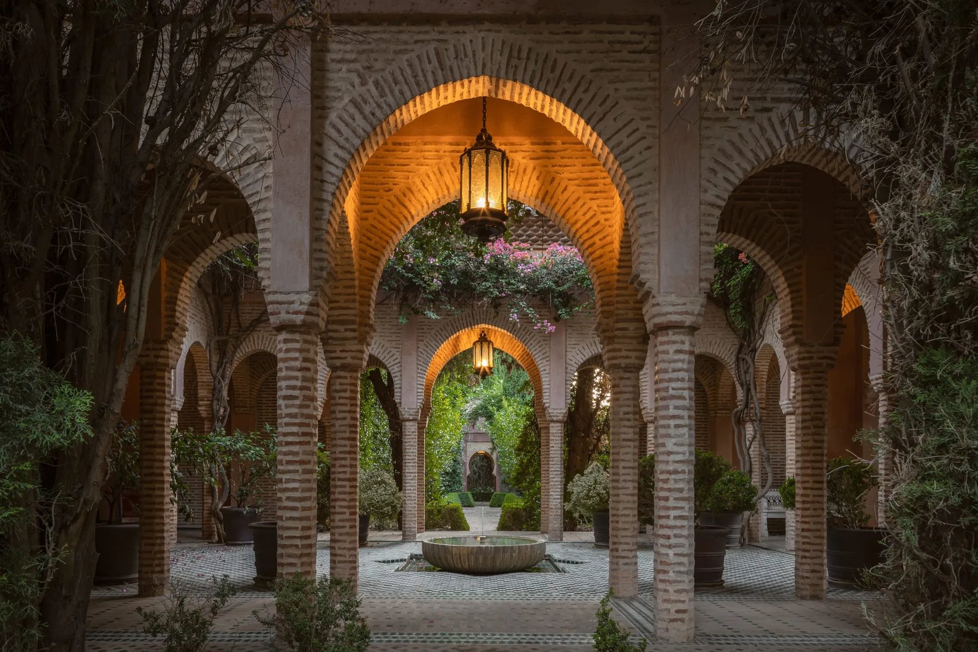 Lantern-lit Moorish colonnade with tiled floor and inner fountain