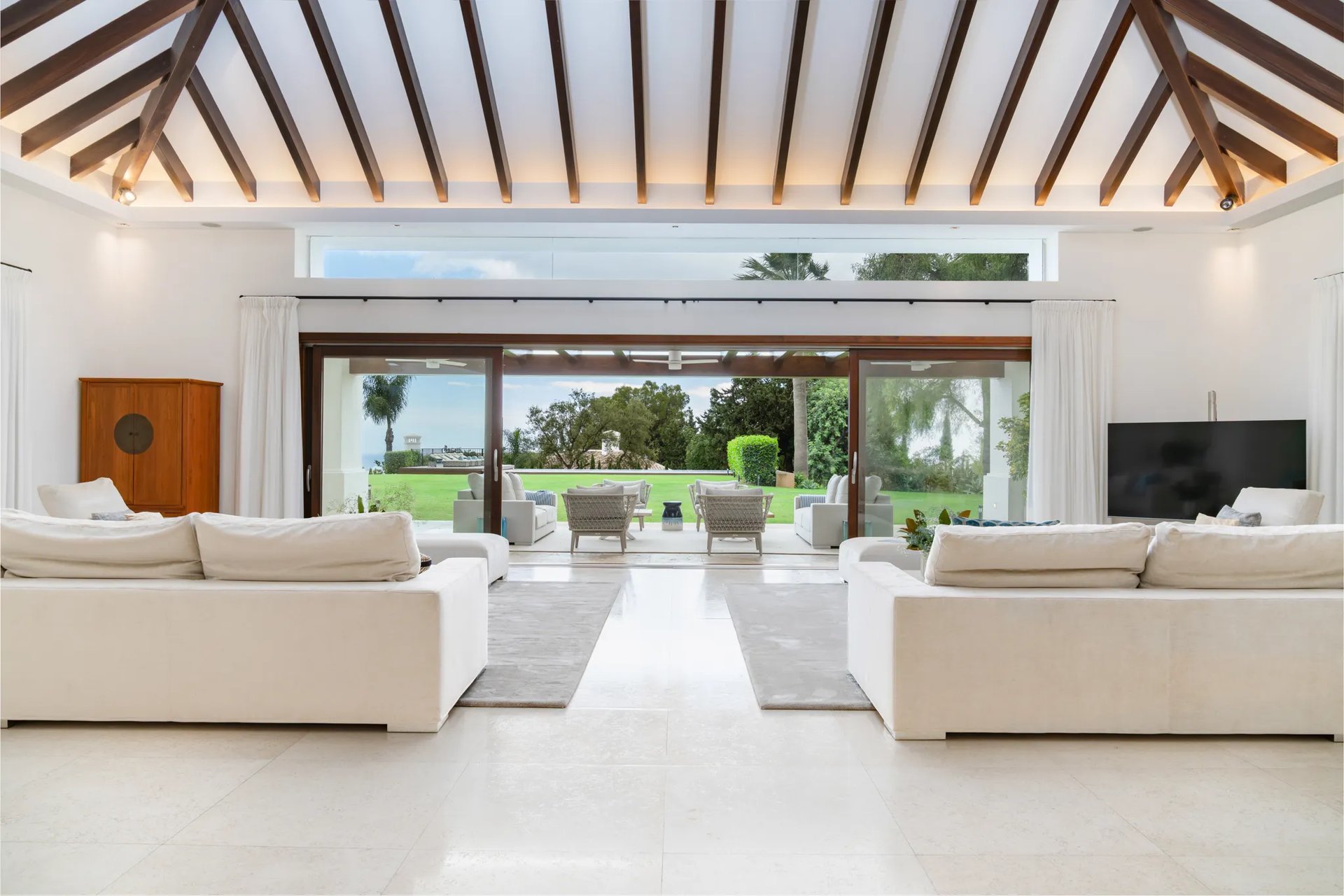 Open-plan living room with wood-beamed ceiling and sea views