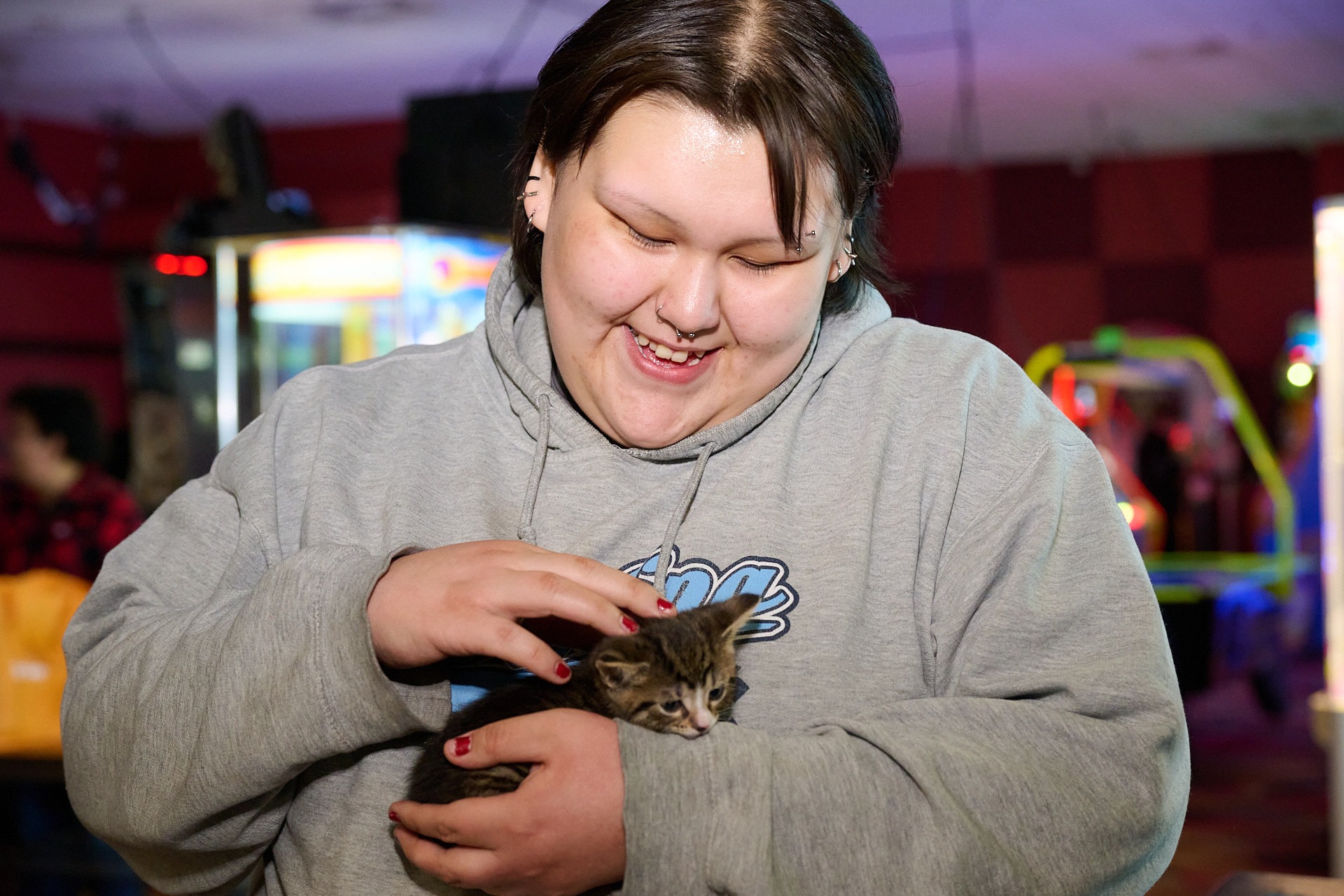 a woman holding a kitten in her hands