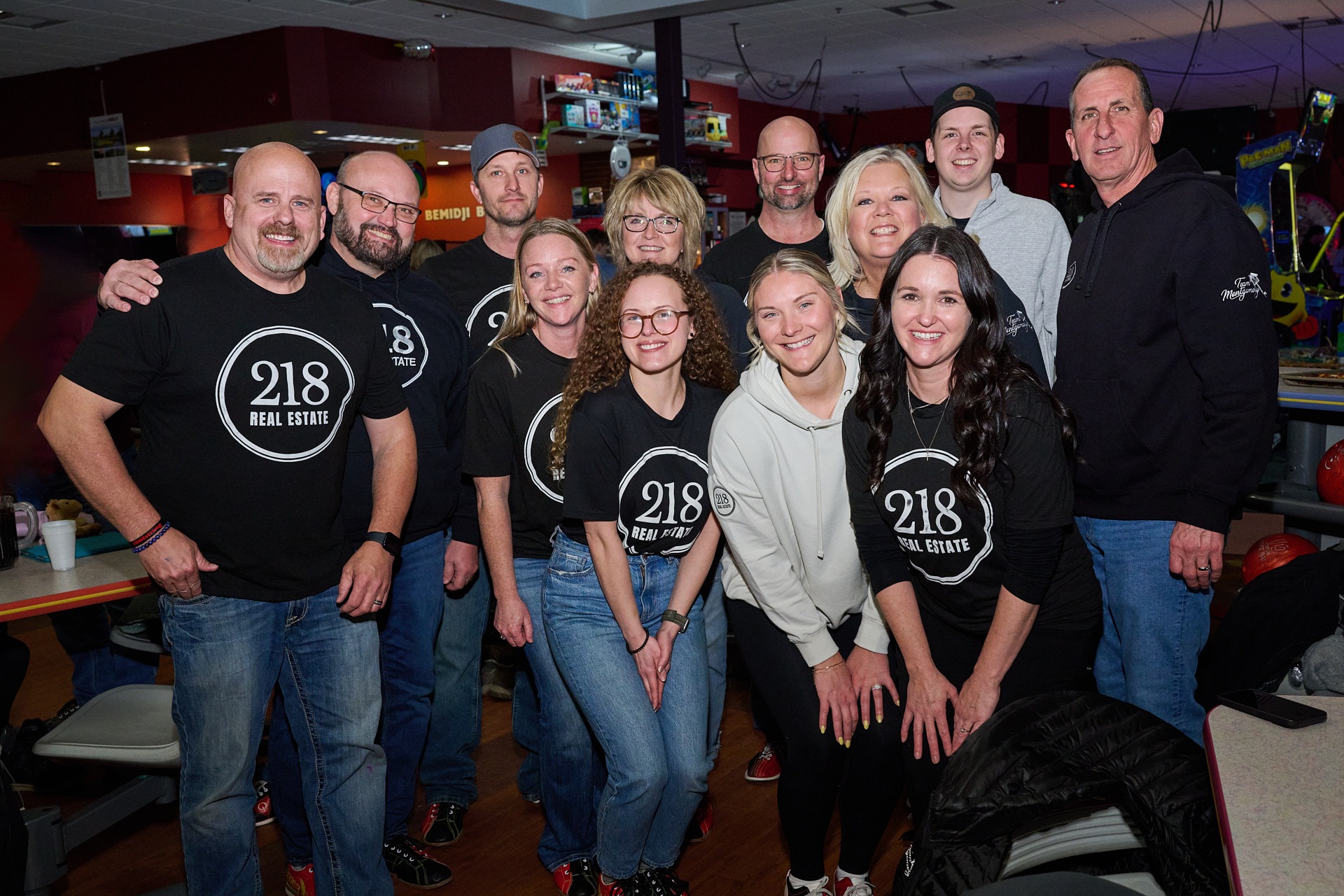 a group of people standing next to a bowling lane