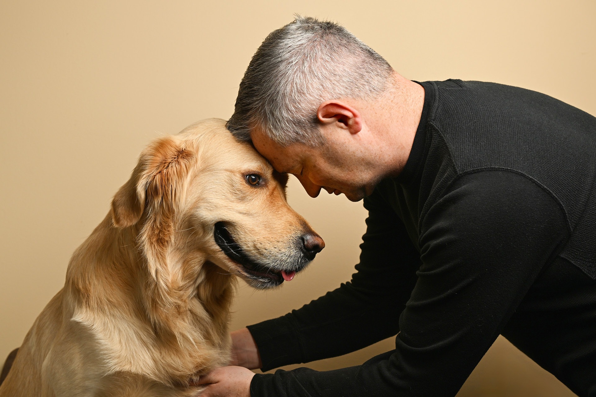 a man is petting a golden retriever