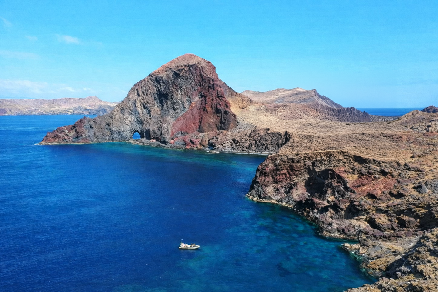 Aerial view of Ponta de São Lourenço volcanic red cliffs, natural arch and turquoise waters, Madeira