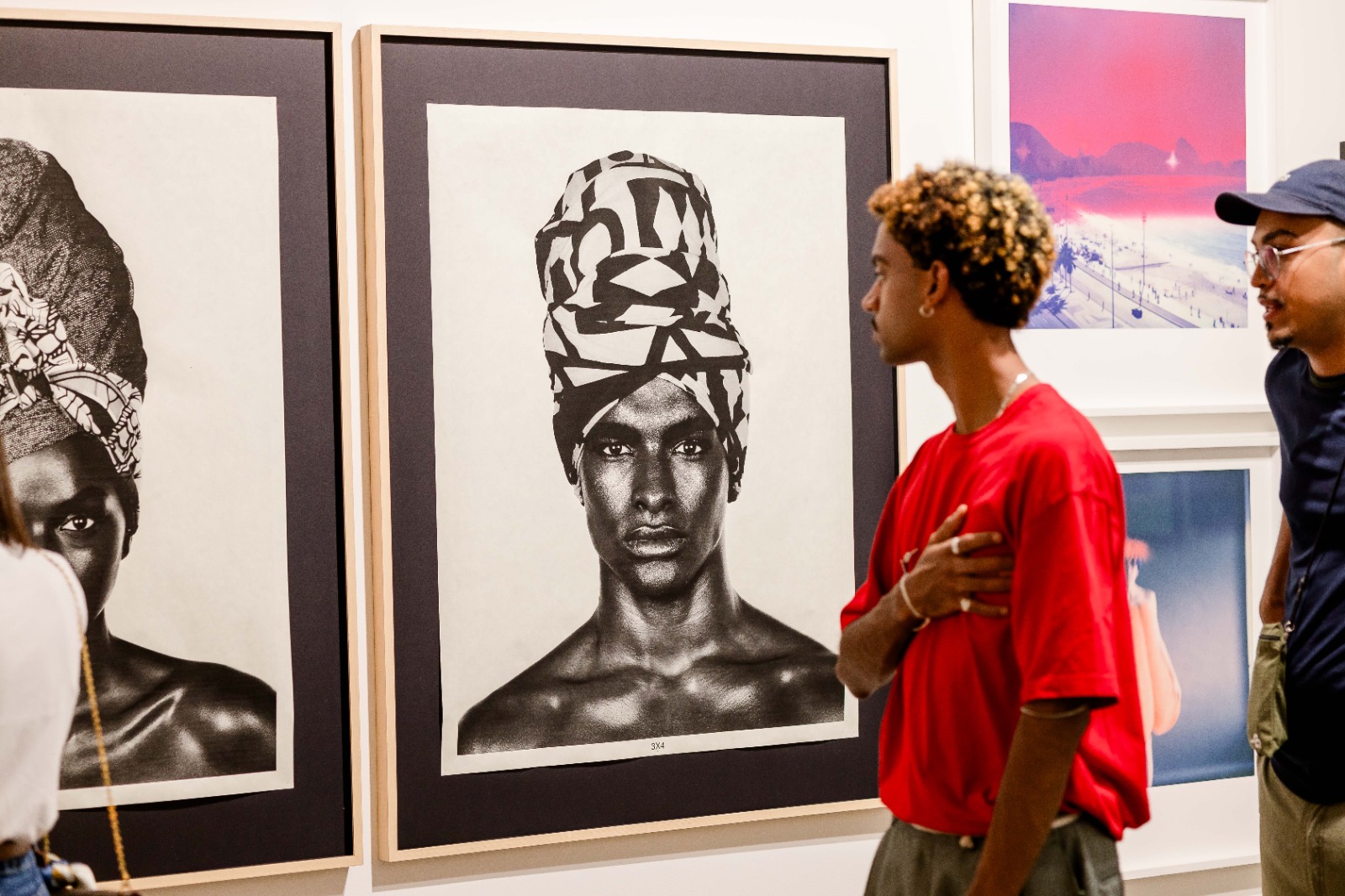 Visitante observando uma fotografia na feira RioArte