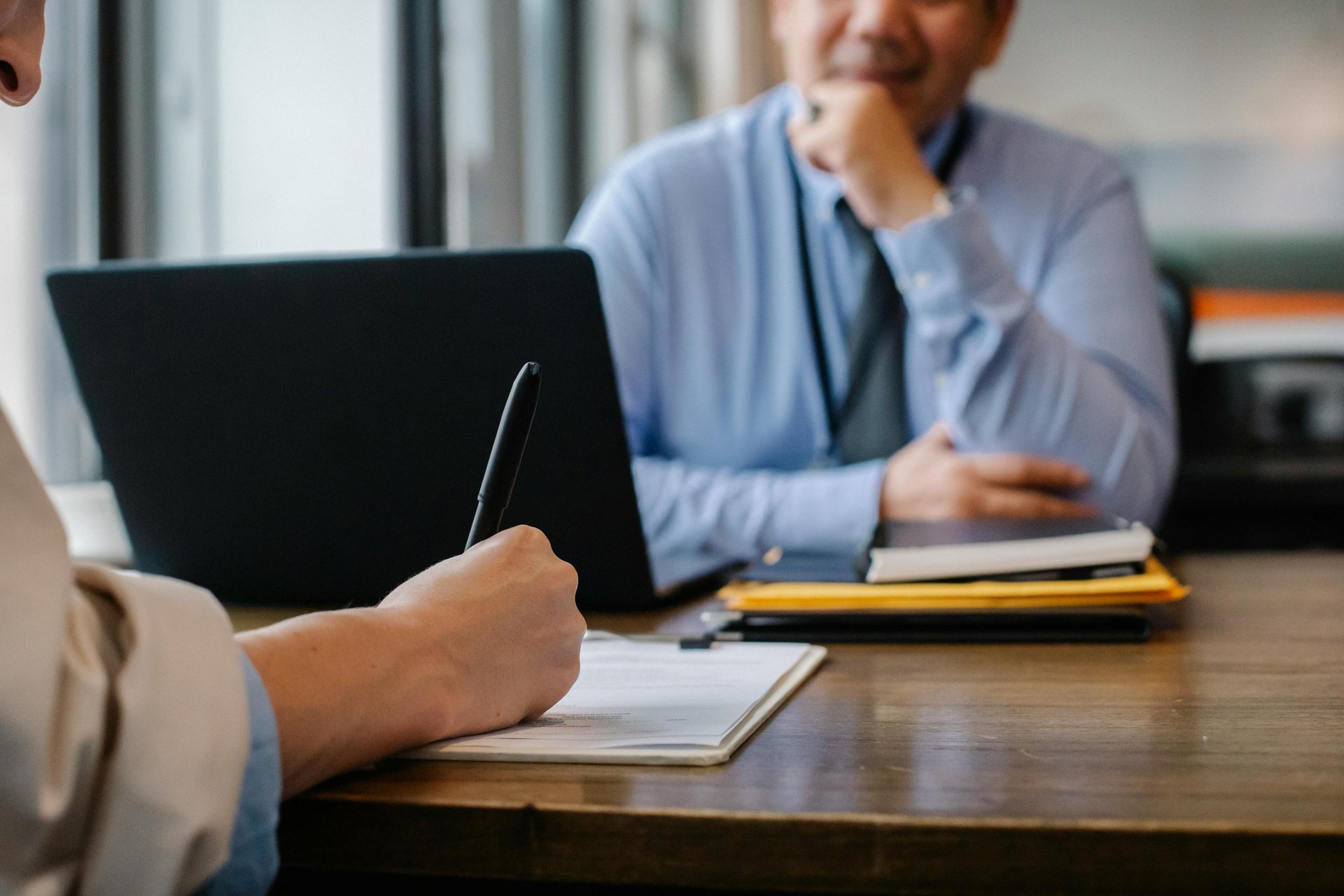 a man sitting at a table with a notebook and pen