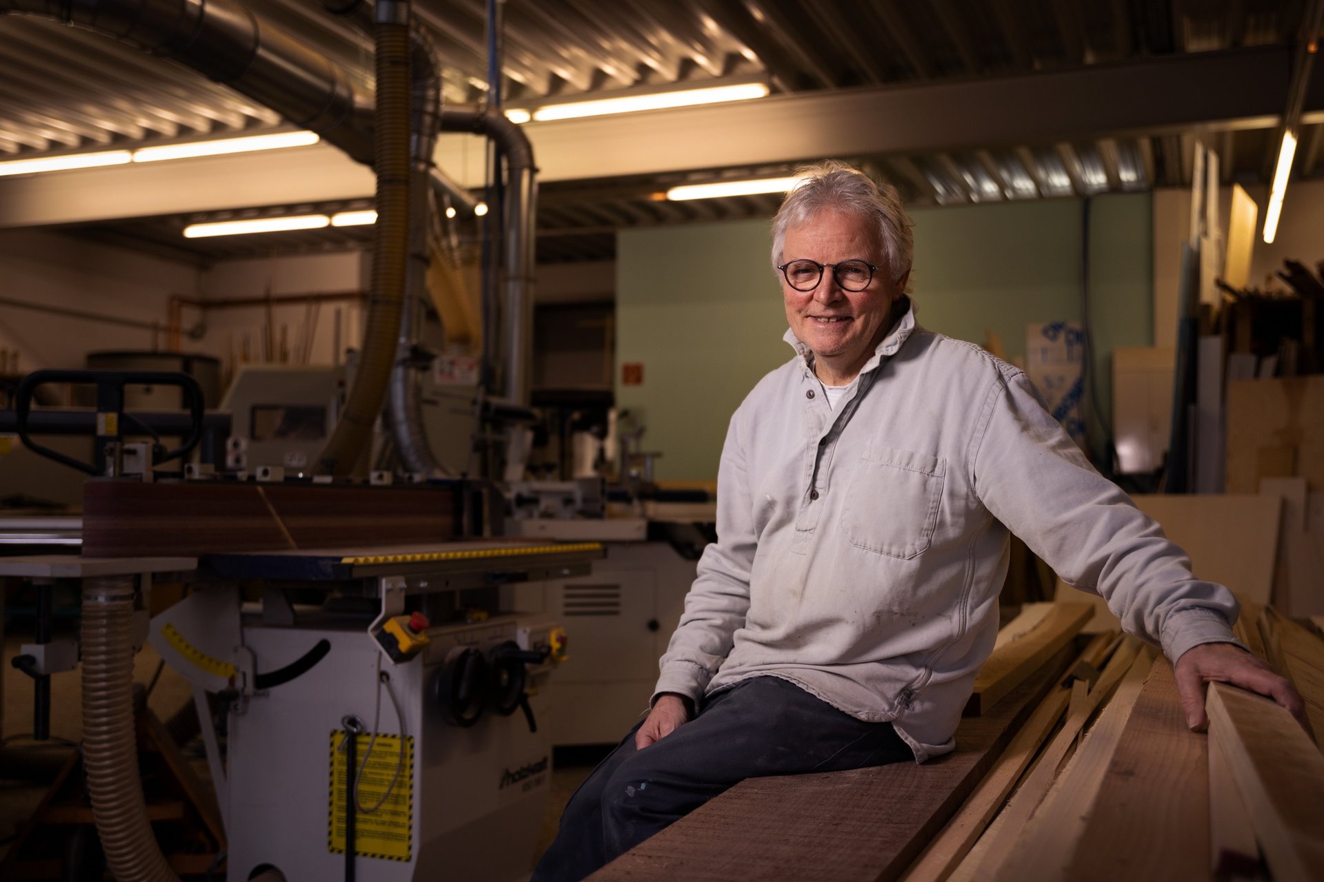 Ein Mann sitzt in der Werkstadt vom Atelier Rohlfs