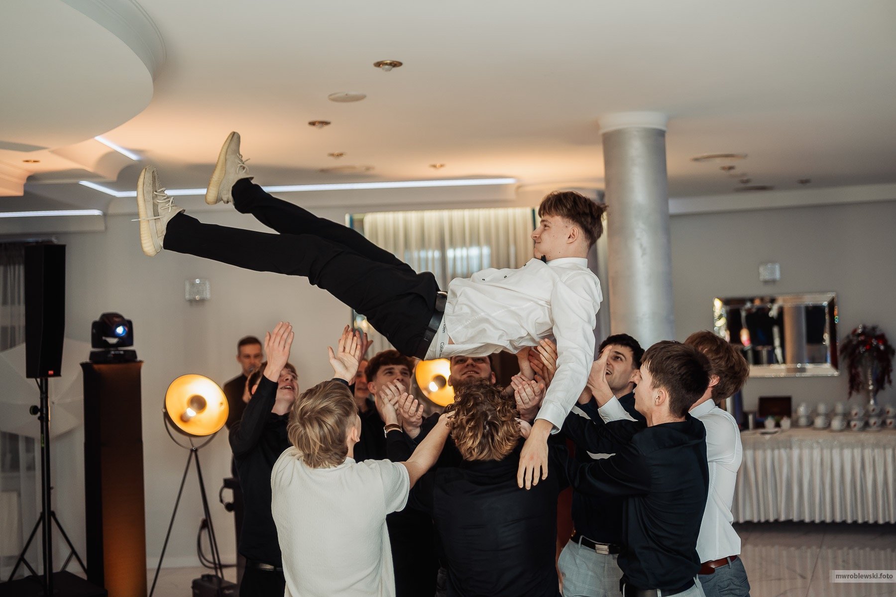 a man is doing a trick on a man in a suit and tie