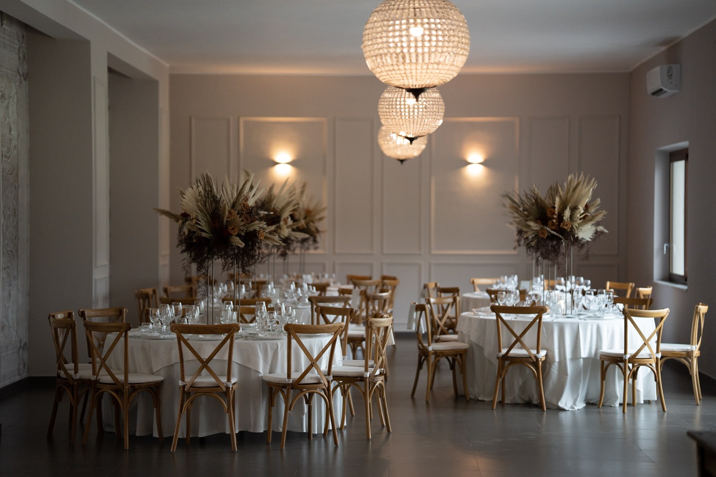 wedding table with white tablecloth and chairs and a chandelier