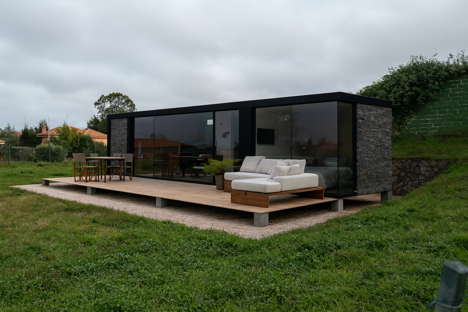 Tiny house de construcción modular con fachada acristalada y terraza de madera