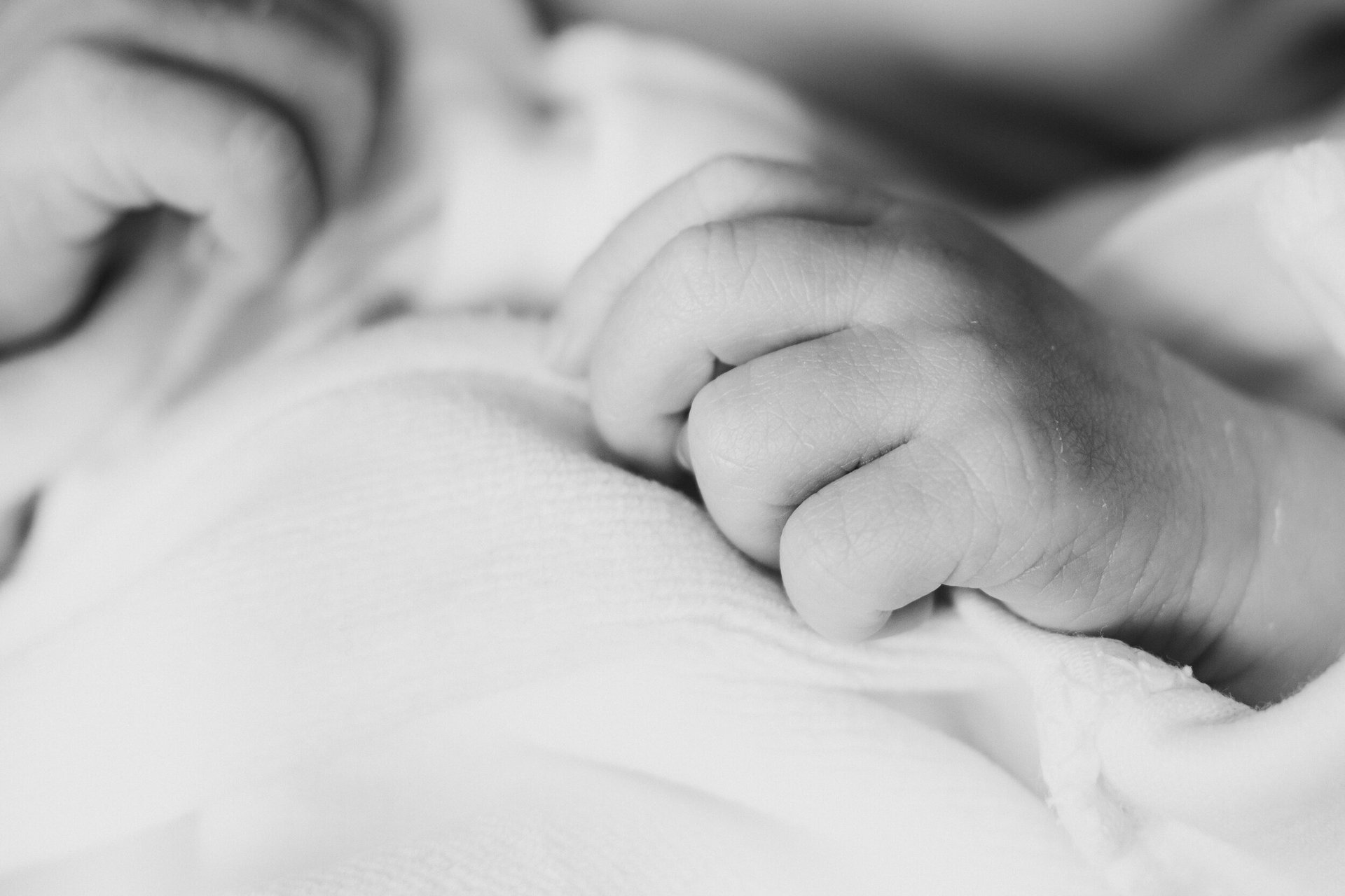 a baby's hand on a blanket