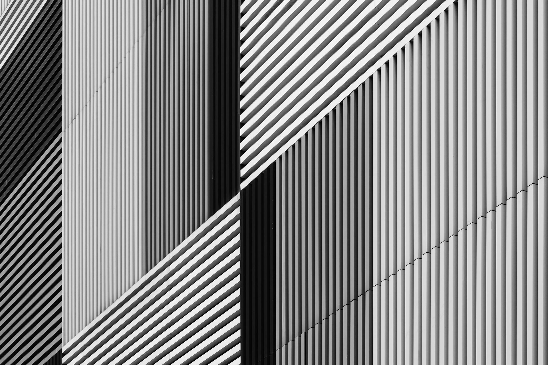 Abstract architectural facade with varying black and white stripes.