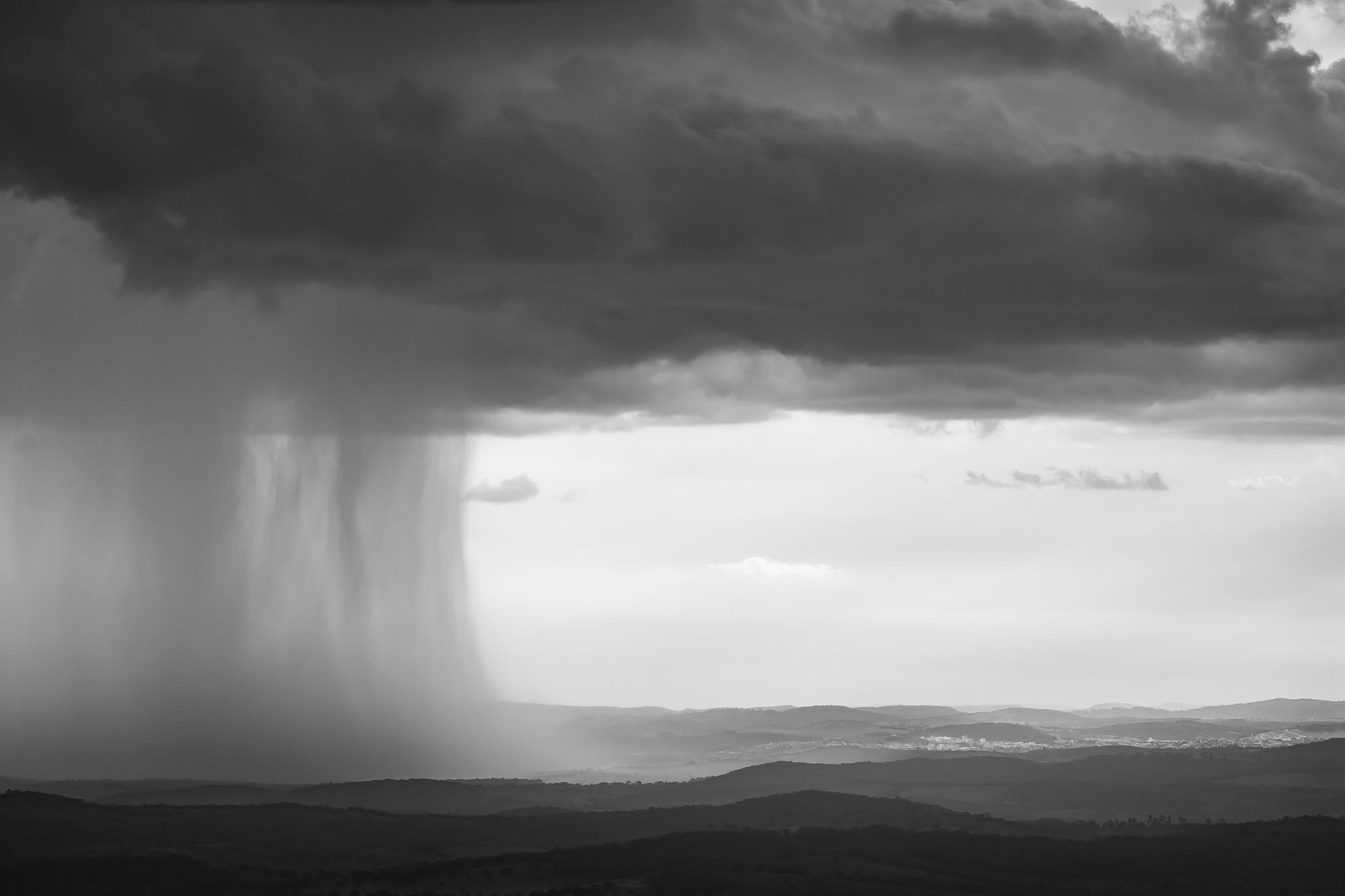 Quadro em preto e branco com fotografia de nuvens de chuva entre as montanhas de Minas Gerais.