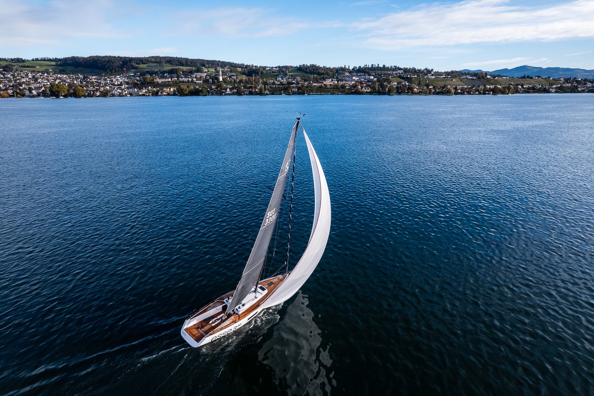 Esse 330 sailboat sailing downwind with a gennaker on calm Lake Zurich