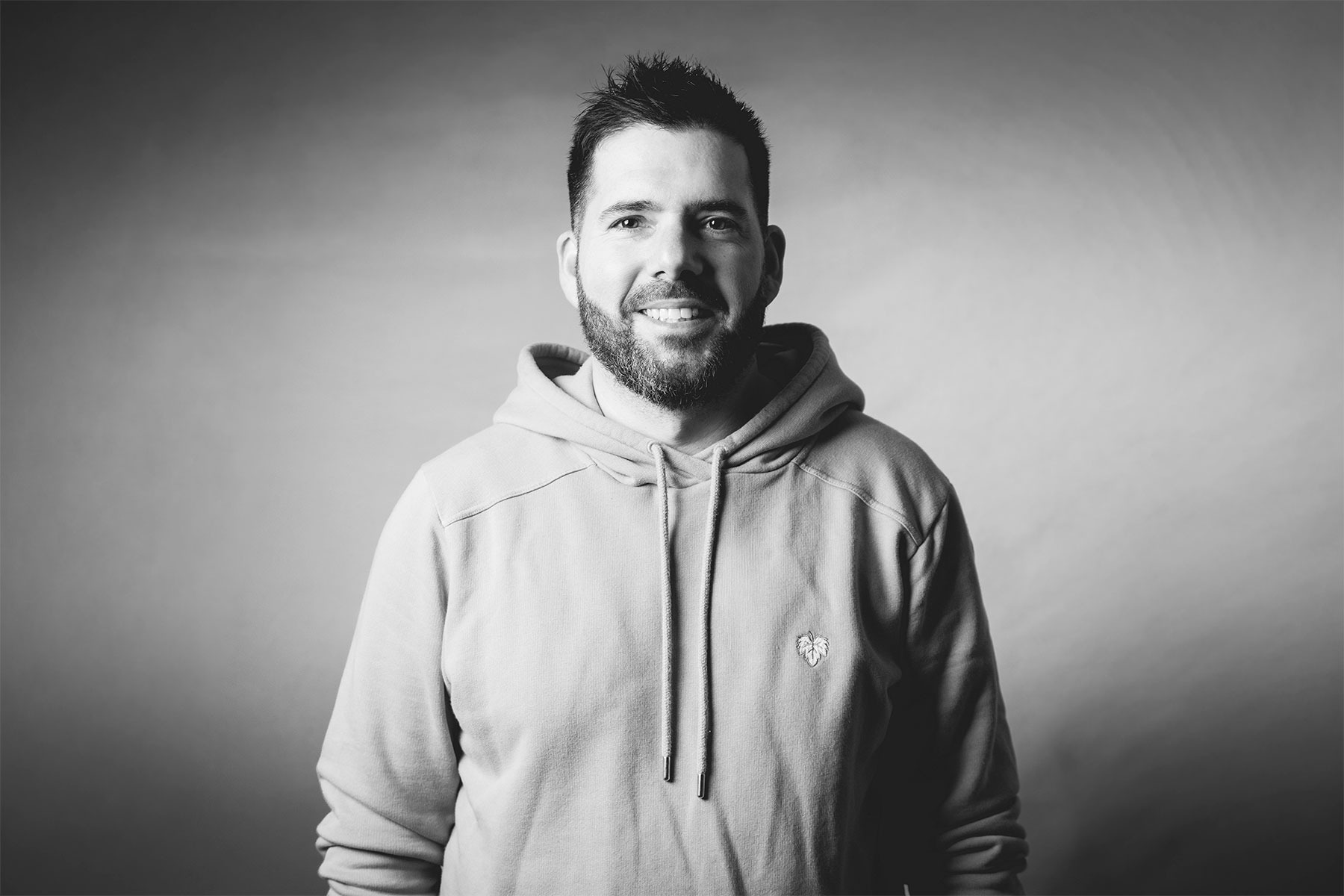 Portrait paysage de Cyril Steau, photographe à Paris, en studio noir et blanc avec éclairage doux et expression naturelle.