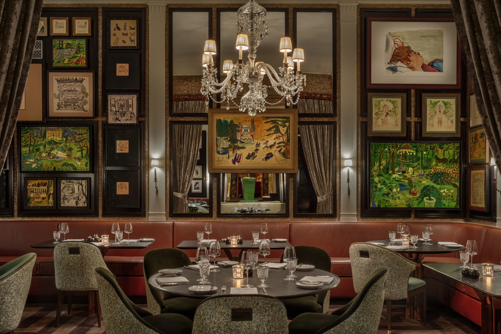 Elegant restaurant dining room with crystal chandelier, gallery wall art, and luxury booths.