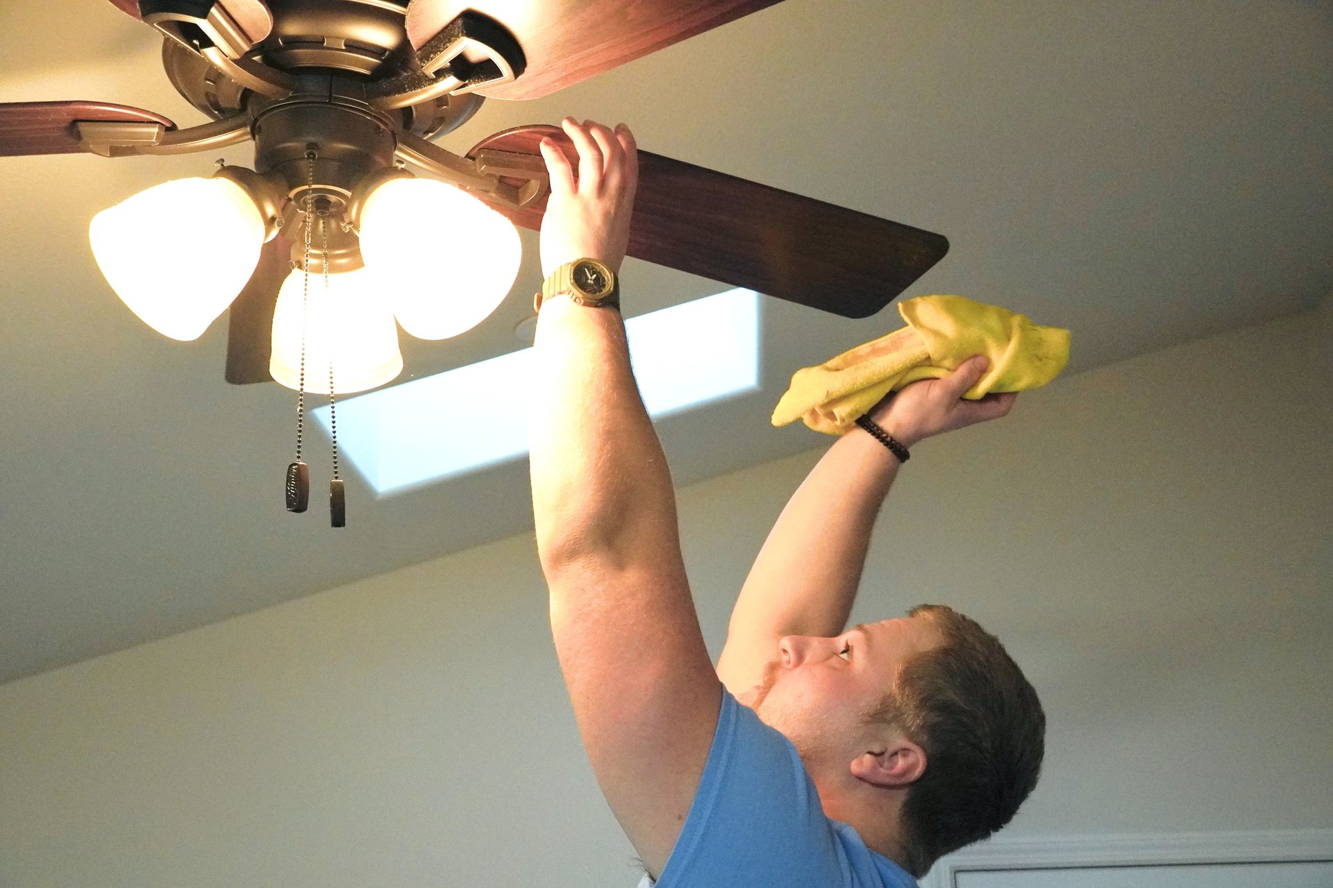 Cleaner from Chez Cleaning Services cleaning a ceiling fan in a house
