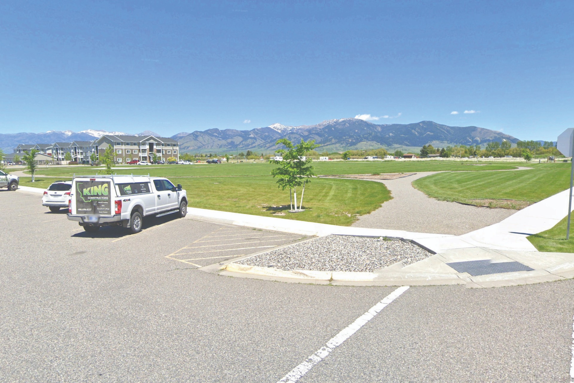 a van parked in a parking lot with mountains in the background