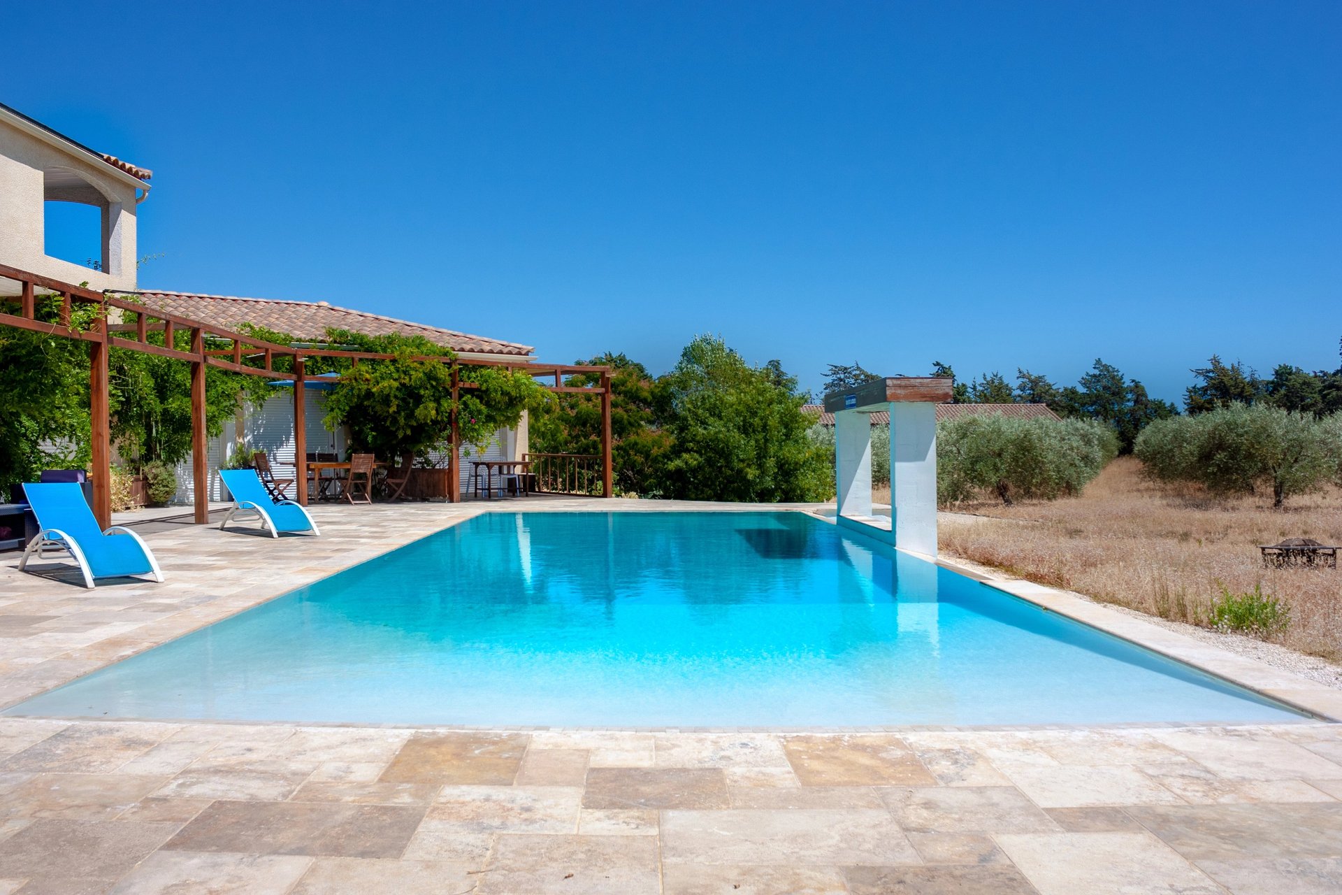 Swimming pool with beach chairs, wide view and waterfall cascade built-in at Domaine Des Lucques