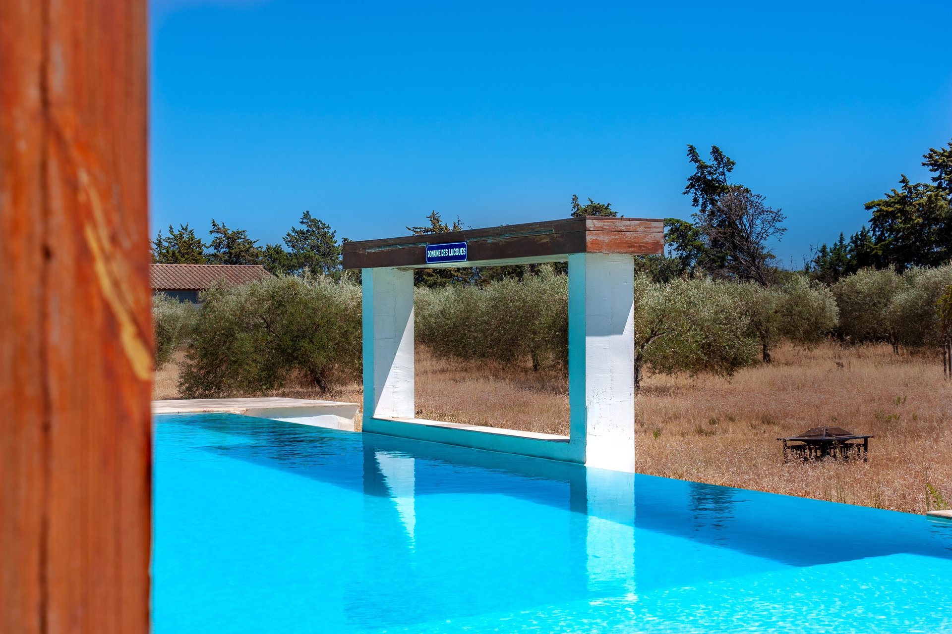 Swimming pool with beach chairs, wide view and waterfall cascade built-in at Domaine Des Lucques
