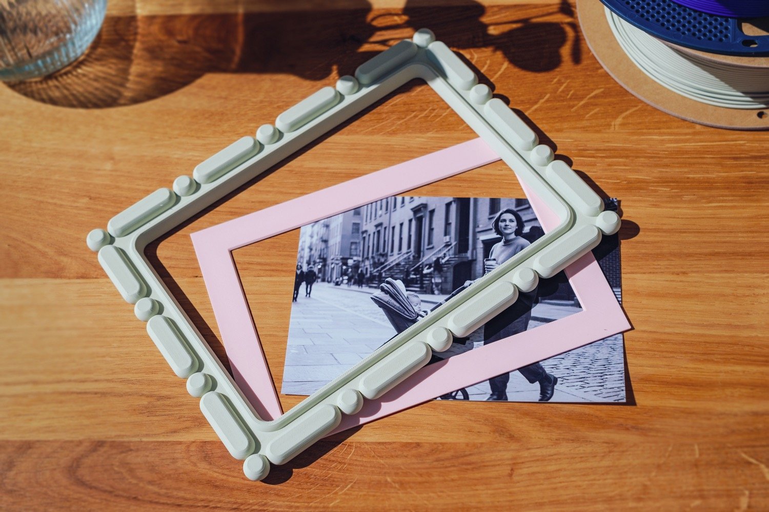 3D printed home decor photo and matboard being placed together, customizable frame design